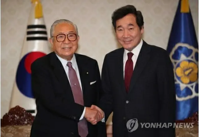 握手を交わす李首相（右）と渡辺秀央氏＝１９日、ソウル（聯合ニュース）