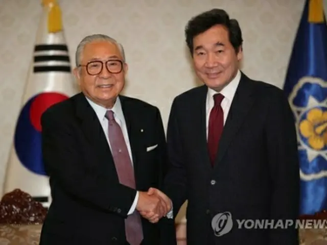 握手を交わす李首相（右）と渡辺秀央氏＝１９日、ソウル（聯合ニュース）