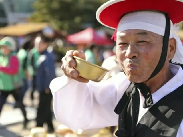 「利川米文化祭り」でマッコリを手に笑顔を見せる関係者＝（聯合ニュース）