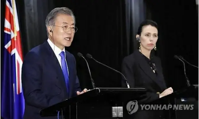共同記者会見を行う文大統領（左）とアーダーン首相＝4日、オークランド（聯合ニュース）