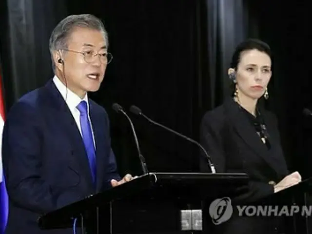 共同記者会見を行う文大統領（左）とアーダーン首相＝4日、オークランド（聯合ニュース）