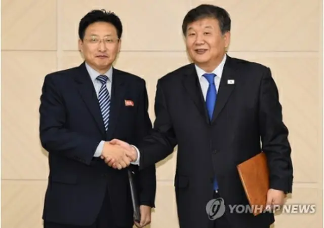 握手する盧泰剛氏（右）と元吉宇氏（写真共同取材団）＝（聯合ニュース）