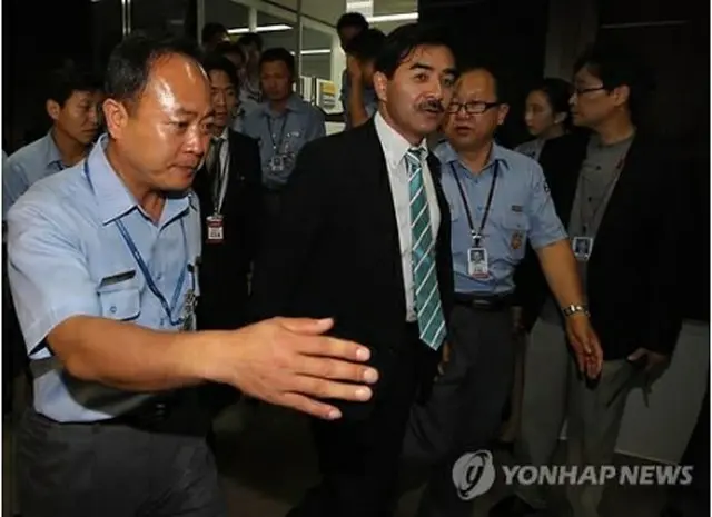２０１１年８月、金浦空港で入国不許可となった後、空港関係者の案内を受けトイレに行く佐藤正久氏（手前から2人目、資料写真）＝（聯合ニュース）
