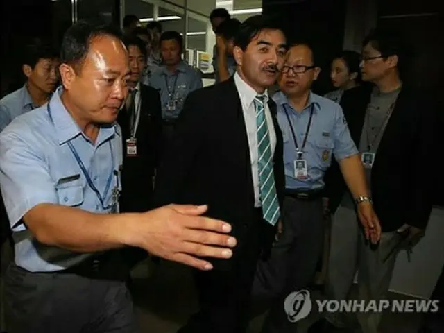 ２０１１年８月、金浦空港で入国不許可となった後、空港関係者の案内を受けトイレに行く佐藤正久氏（手前から2人目、資料写真）＝（聯合ニュース）