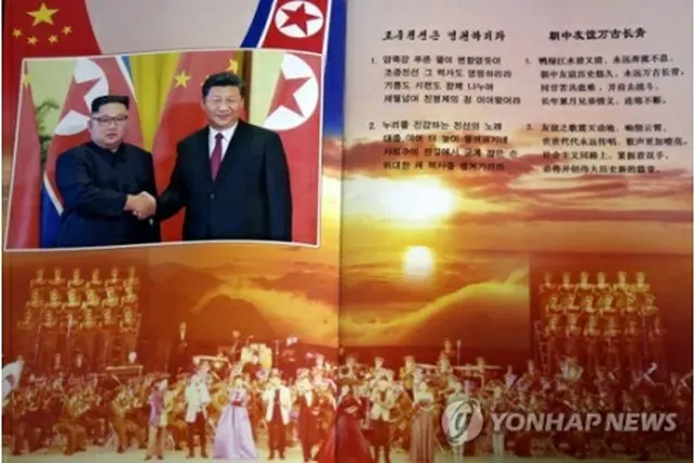 北朝鮮の金正恩・国務委員長（朝鮮労働党委員長）と中国の習近平国家主席が握手する姿が掲載されている公演のパンフレット＝（聯合ニュース）