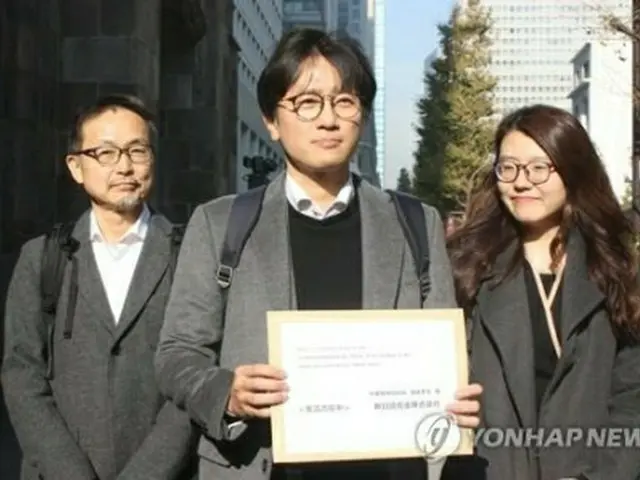 昨年12月4日、判決の履行を求める協議要請書を手渡すため、新日鉄本社を訪れた原告の代理人ら＝（聯合ニュース）