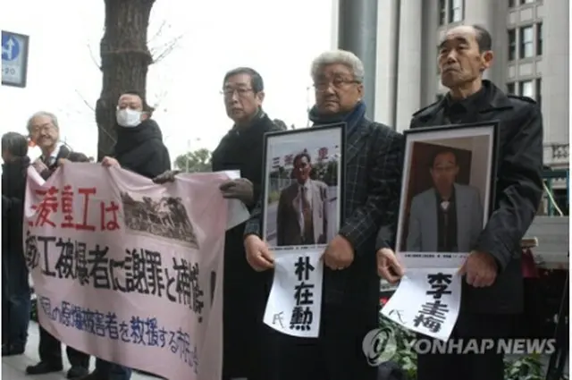 三菱重工の本社前に立つ原告遺族と支援者ら＝15日、東京（聯合ニュース）
