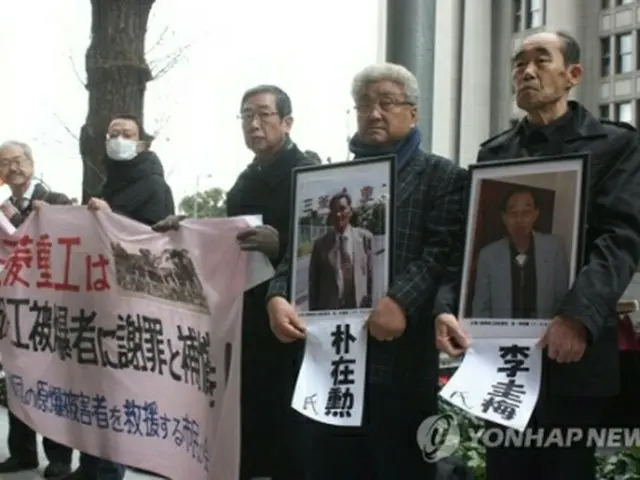 三菱重工の本社前に立つ原告遺族と支援者ら＝１５日、東京（聯合ニュース）