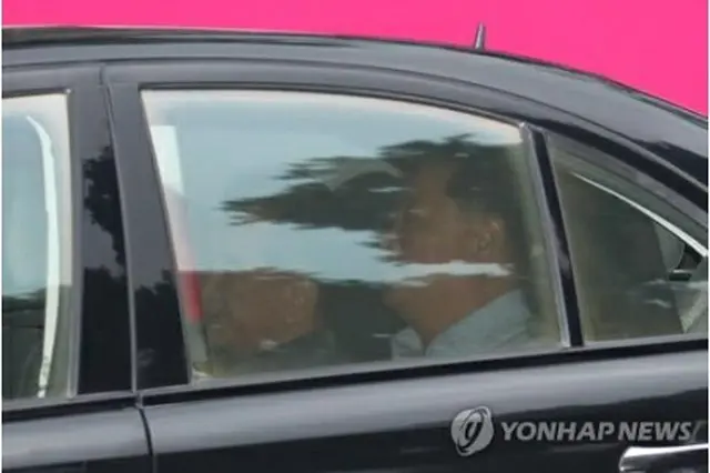 車に乗って宿泊先を出発するキム氏（左）＝１７日、ハノイ（聯合ニュース）