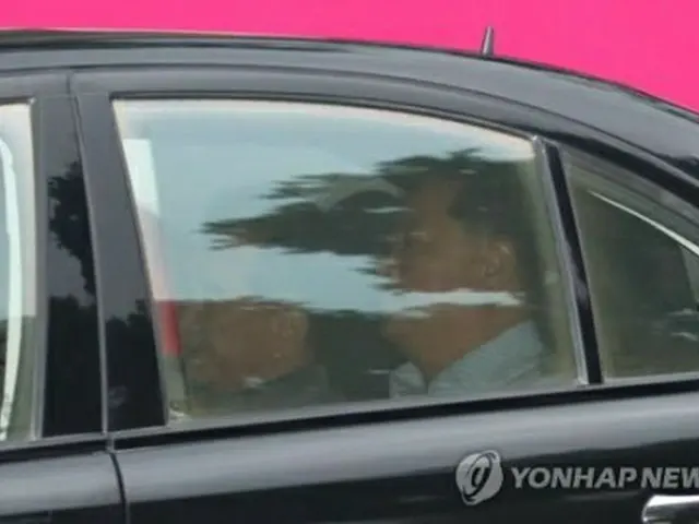 車に乗って宿泊先を出発するキム氏（左）＝１７日、ハノイ（聯合ニュース）