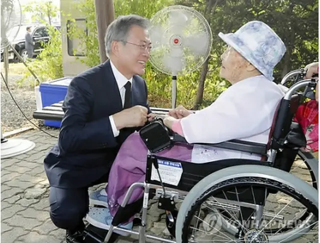 昨年８月１４日、国立墓地「望郷の丘」で文在寅（ムン・ジェイン）大統領とあいさつするクァクさん＝（聯合ニュース）