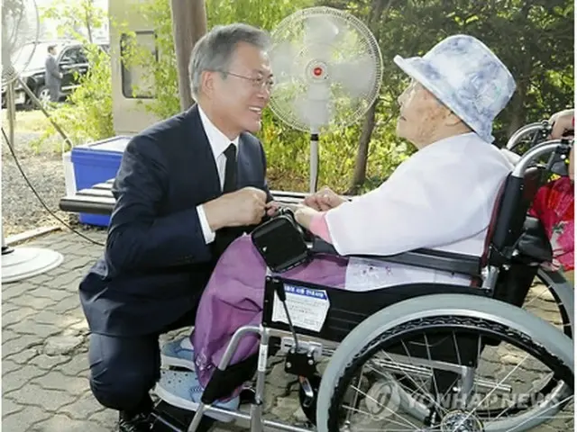 昨年８月１４日、国立墓地「望郷の丘」で文在寅（ムン・ジェイン）大統領とあいさつするクァクさん＝（聯合ニュース）