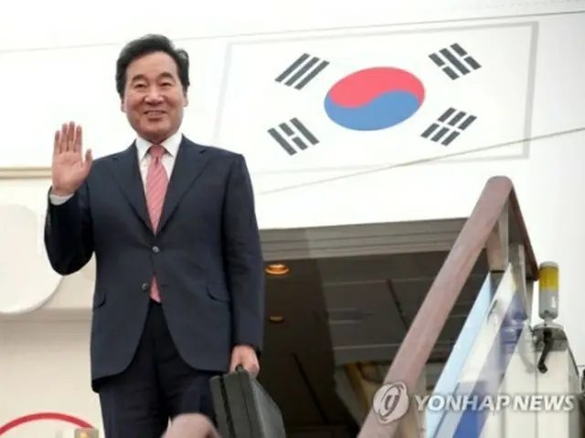 ソウル空港で、出発前に手を振る李首相＝２５日、城南（聯合ニュース）