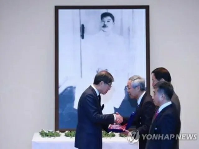 追悼式で感謝の盾を受け取る鈴木氏（右）＝26日、ソウル（聯合ニュース）