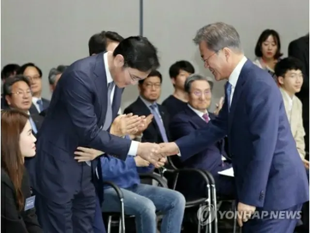 サムスングループの事実上の経営トップ、李在鎔（イ・ジェヨン）サムスン電子副会長（左）と握手を交わす文大統領=３０日、華城（聯合ニュース）
