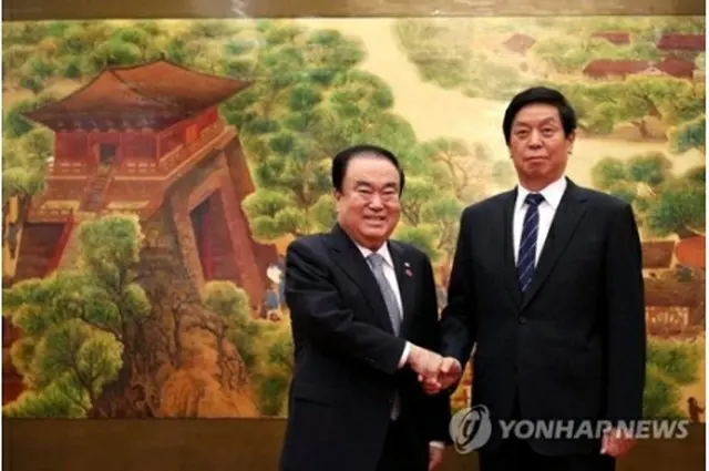 握手を交わす文喜相国会議長（左）と栗戦書氏（国会提供）＝（聯合ニュース）