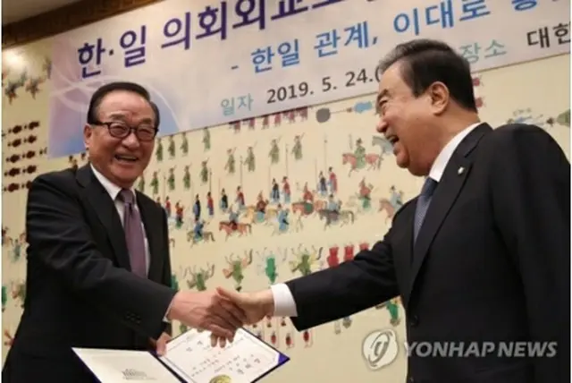徐氏（左）に会長任命状を授与する文氏＝２４日、ソウル（聯合ニュース）