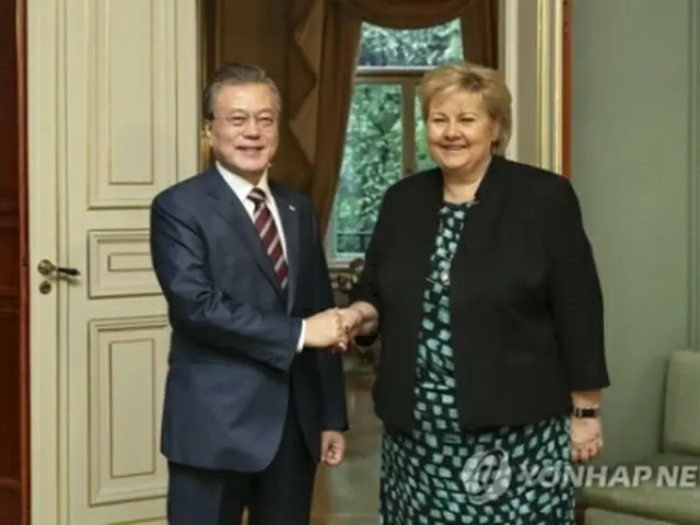 握手する文大統領（左）とソルベルグ首相＝１３日、オスロ（聯合ニュース）