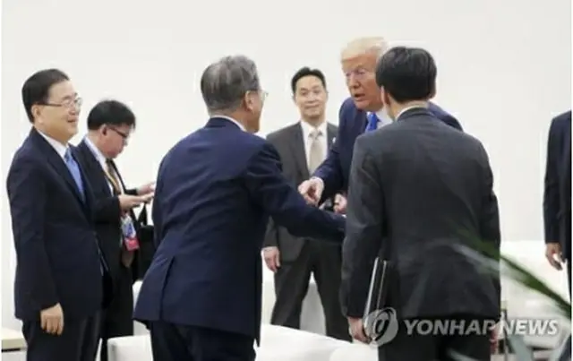 Ｇ２０開催中、コーヒーを飲んでいた文大統領に声をかけるトランプ氏＝２９日、大阪（聯合ニュース）