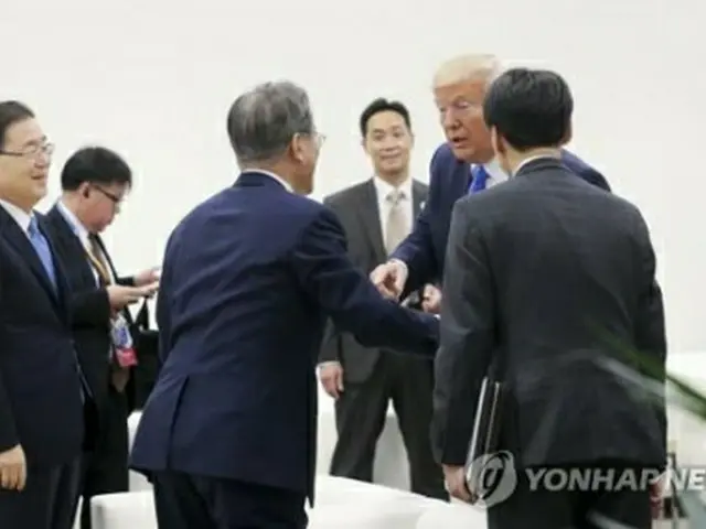 Ｇ２０開催中、コーヒーを飲んでいた文大統領に声をかけるトランプ氏＝２９日、大阪（聯合ニュース）