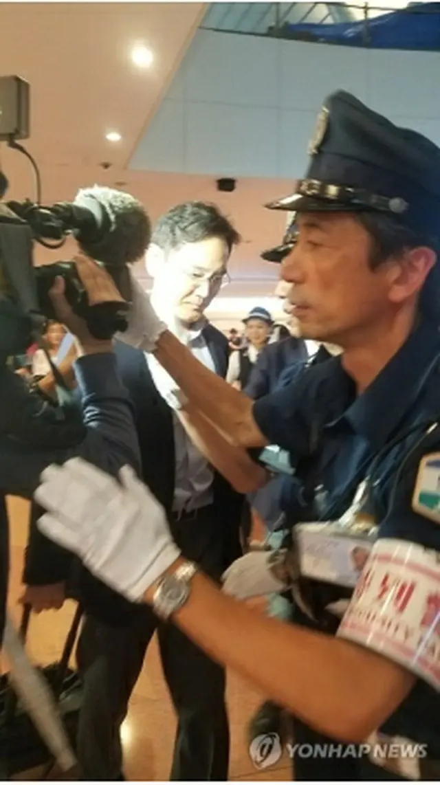 7日夜、羽田空港に到着後、報道陣に囲まれる李在鎔氏＝（聯合ニュース）