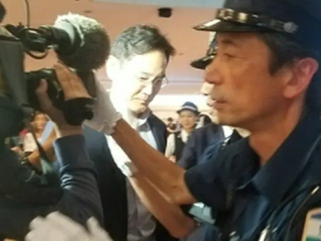 7日夜、羽田空港に到着後、報道陣に囲まれる李在鎔氏＝（聯合ニュース）