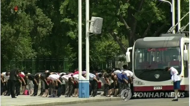 ８日正午、サイレンに合わせて錦繻山太陽宮殿に向かって黙とうする北朝鮮住民＝（朝鮮中央テレビ＝聯合ニュース）≪転載・転用禁止≫