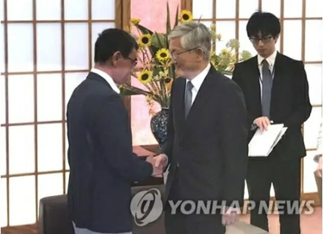 外務省で握手を交わす南氏（右）と河野氏＝19日、東京（聯合ニュース）