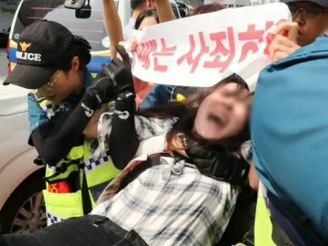 日本総領事館内で対韓輸出規制強化に抗議するパフォーマンスを行い連行される若者（釜山日報提供、転載・転用禁止）＝２２日、釜山（聯合ニュース）