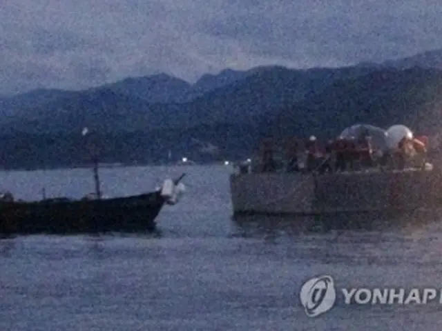 韓国の艦艇にえい航される木造船（左、軍合同参謀本部提供）＝29日、ソウル（聯合ニュース）《転載・転用禁止》