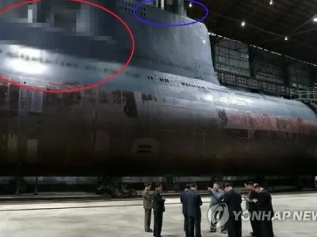 北朝鮮の朝鮮中央テレビは２３日、金委員長が新たに建造された潜水艦を視察したと報じた。視察場面の写真では、ＳＬＢＭの発射管が位置していると推定される部分（赤い囲み）とレーダーや潜望鏡があるとみられる部分（青い囲み）がモザイク処理された＝（聯合
