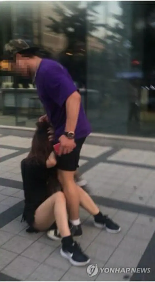 男が女性に暴行を加える様子をとらえた写真（ツイッターより）＝（聯合ニュース）≪転載・転用禁止≫