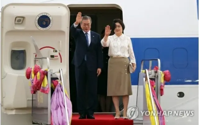 タイ・バンコクのドンムアン空港に到着後、手を振る文大統領夫妻＝１日、バンコク（聯合ニュース）