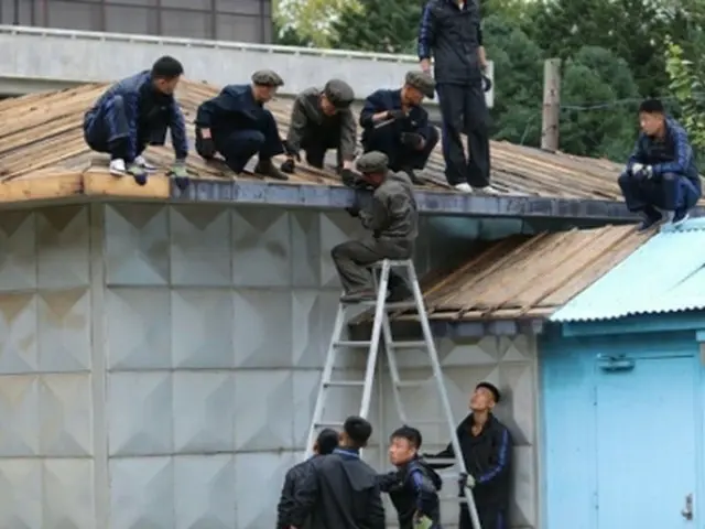 屋根の補修作業を行う北朝鮮の作業員ら（国連軍司令部ツイッターより）＝（聯合ニュース）