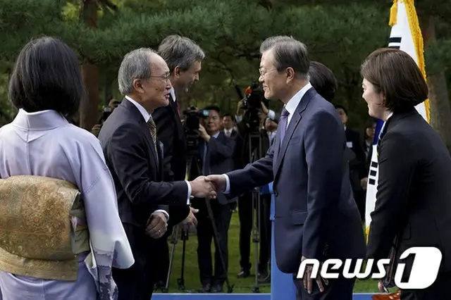 18日、青瓦台（韓国大統領府）でのレセプションで文在寅（ムン・ジェイン）韓国大統領と長嶺安政大使が握手をしている（提供:news1）