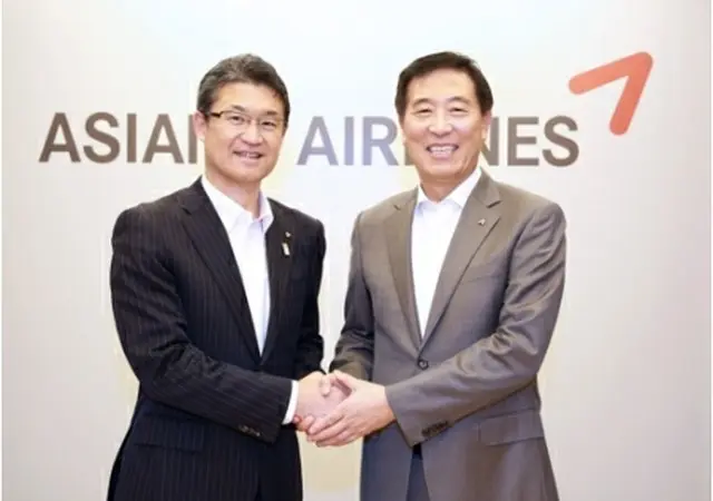握手を交わす韓昌洙社長（右）と河野俊嗣知事（アシアナ航空提供）＝（聯合ニュース）≪転載・転用禁止≫