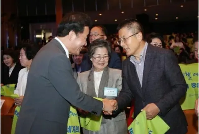 10月31日にソウル市内で開かれた全国女性大会で握手を交わす李氏（左）と黄氏＝（聯合ニュース）