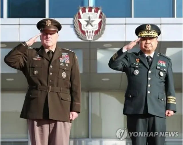 韓国軍合同参謀本部で開かれた歓迎式典で敬礼する朴氏（右）とミリー氏＝14日、ソウル（聯合ニュース）