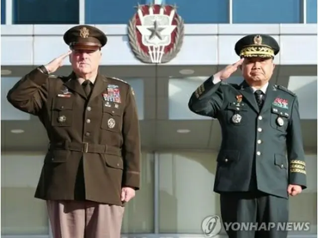 韓国軍合同参謀本部で開かれた歓迎式典で敬礼する朴氏（右）とミリー氏＝14日、ソウル（聯合ニュース）