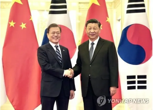 握手を交わす文大統領（左）と習近平主席＝２３日、北京（聯合ニュース）