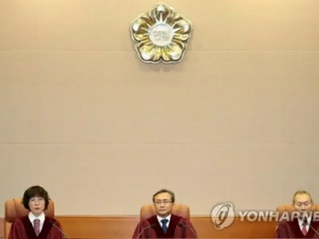 憲法裁の大審判廷に入廷した劉南碩（ユ・ナムソク）憲法裁判所長（中央）ら＝２７日、ソウル（聯合ニュース）