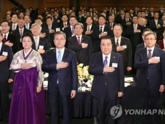 新年会で国旗に敬礼する文大統領（手前中央）＝２日、ソウル（聯合ニュース）
