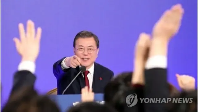 青瓦台での会見で質問を希望する記者を指名する文大統領＝14日、ソウル（聯合ニュース）