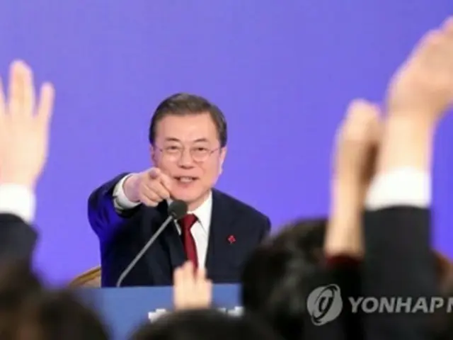 青瓦台での会見で質問を希望する記者を指名する文大統領＝14日、ソウル（聯合ニュース）