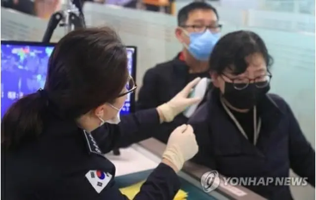 済州国際空港で空港関係者が中国・南京からの入国者の体温をチェックしている＝23日、済州（聯合ニュース）