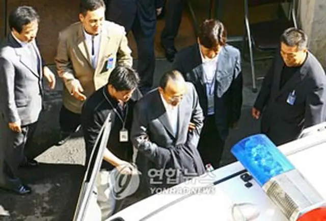 パトカーに乗り込む金升淵会長＝17日、ソウル（聯合）