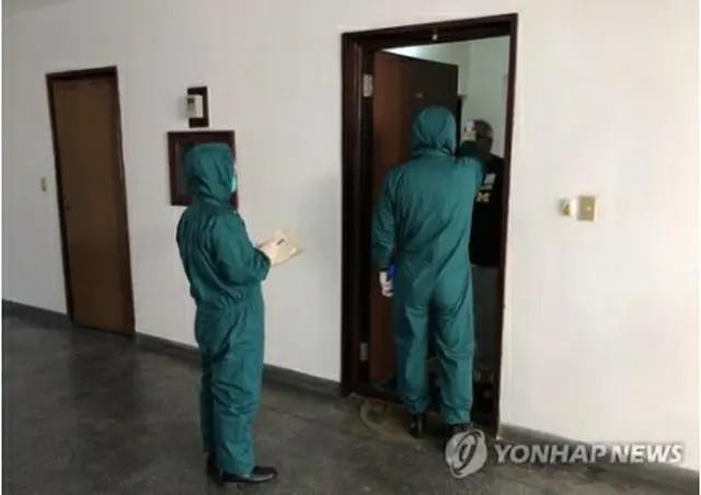 外国人の体温検査を行う北朝鮮の防疫要員＝（タス通信＝聯合ニュース）