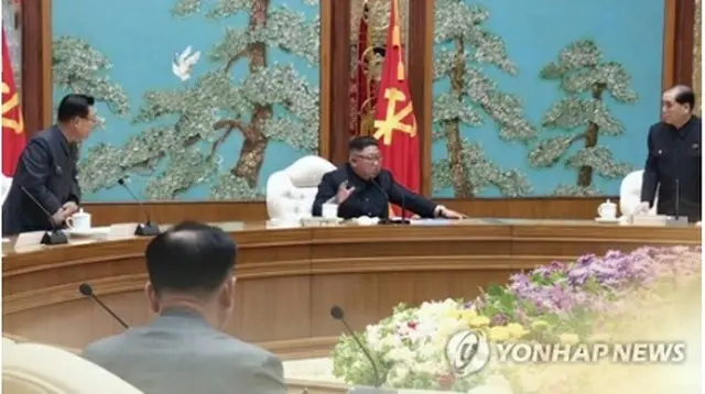 金正恩国務委員長（朝鮮労働党委員長、中央）が主宰した１１日の党政治局会議で、新型コロナウイルスへの対策が協議された。長期戦の構えを示したようだ＝（聯合ニュースＴＶ）