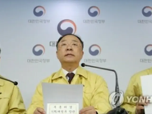 記者会見を行う洪副首相（中央）＝
