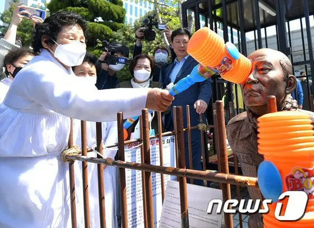 27日、韓国光州の裁判所の前で全斗煥氏のひざまづいた銅像を叩く市民（提供:news1）